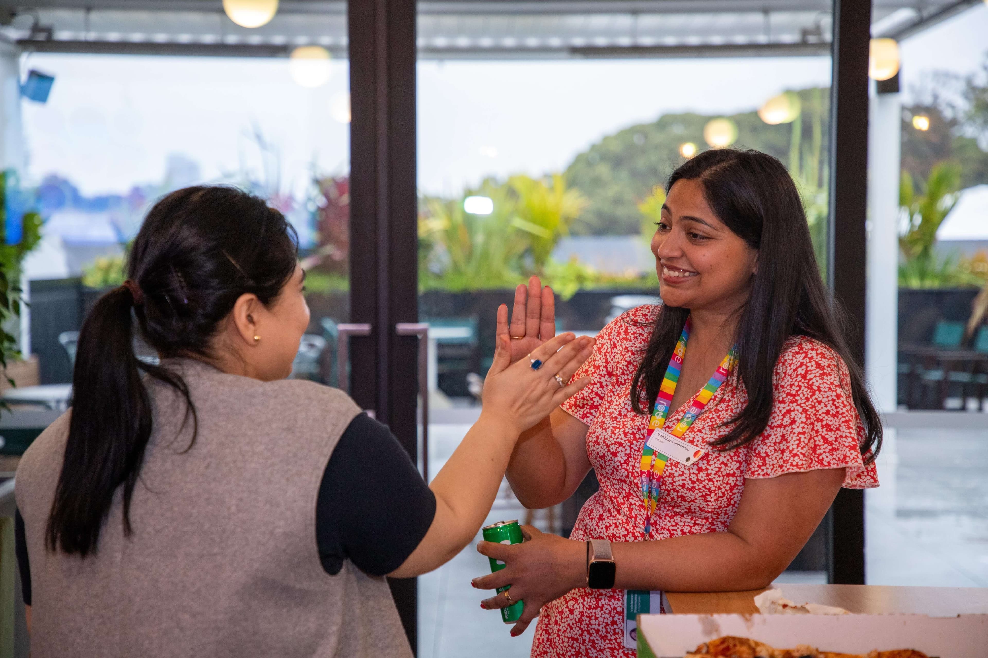 Four women at She Sharp event, one speaking into a microphone