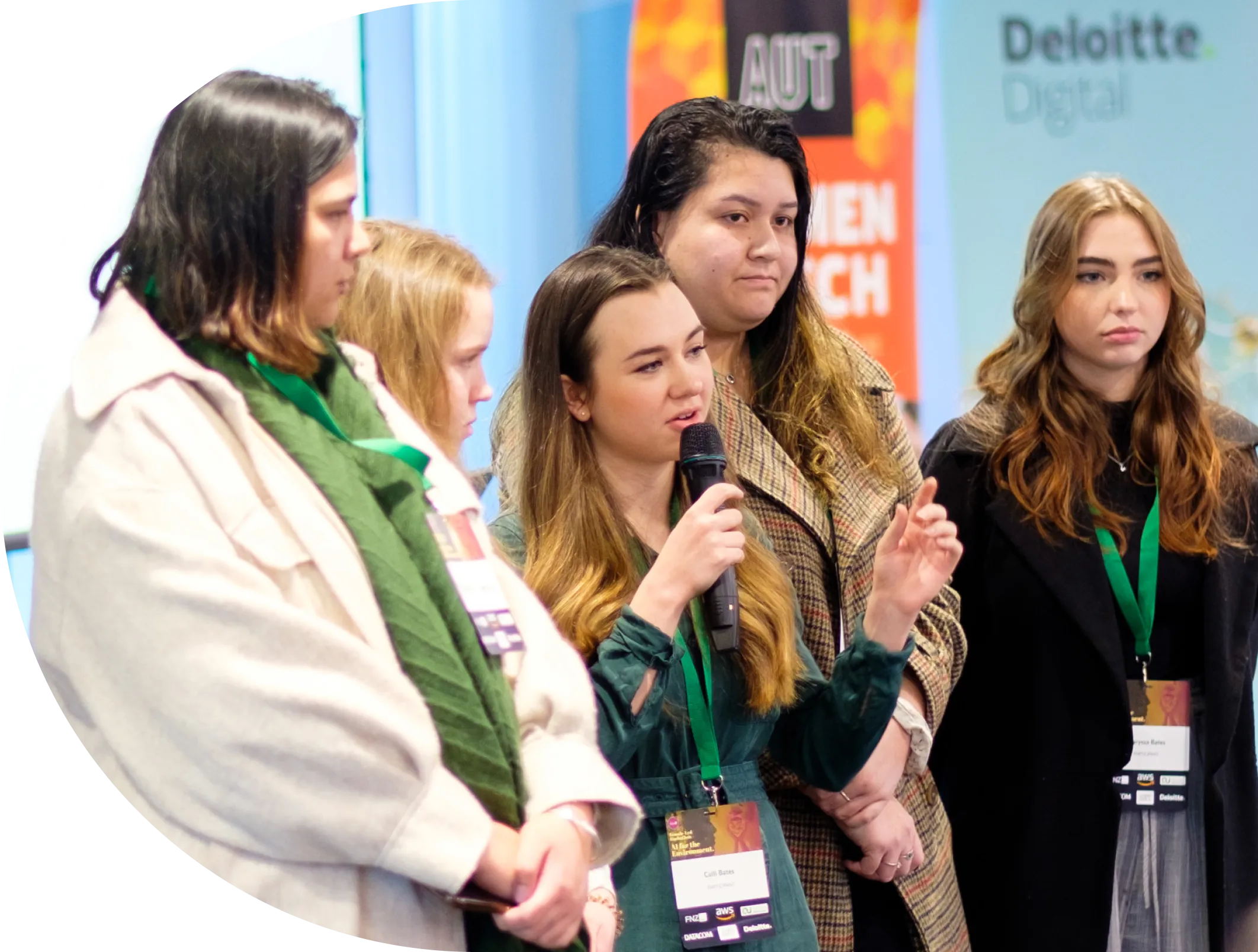 Four women at She Sharp event, one speaking into a microphone